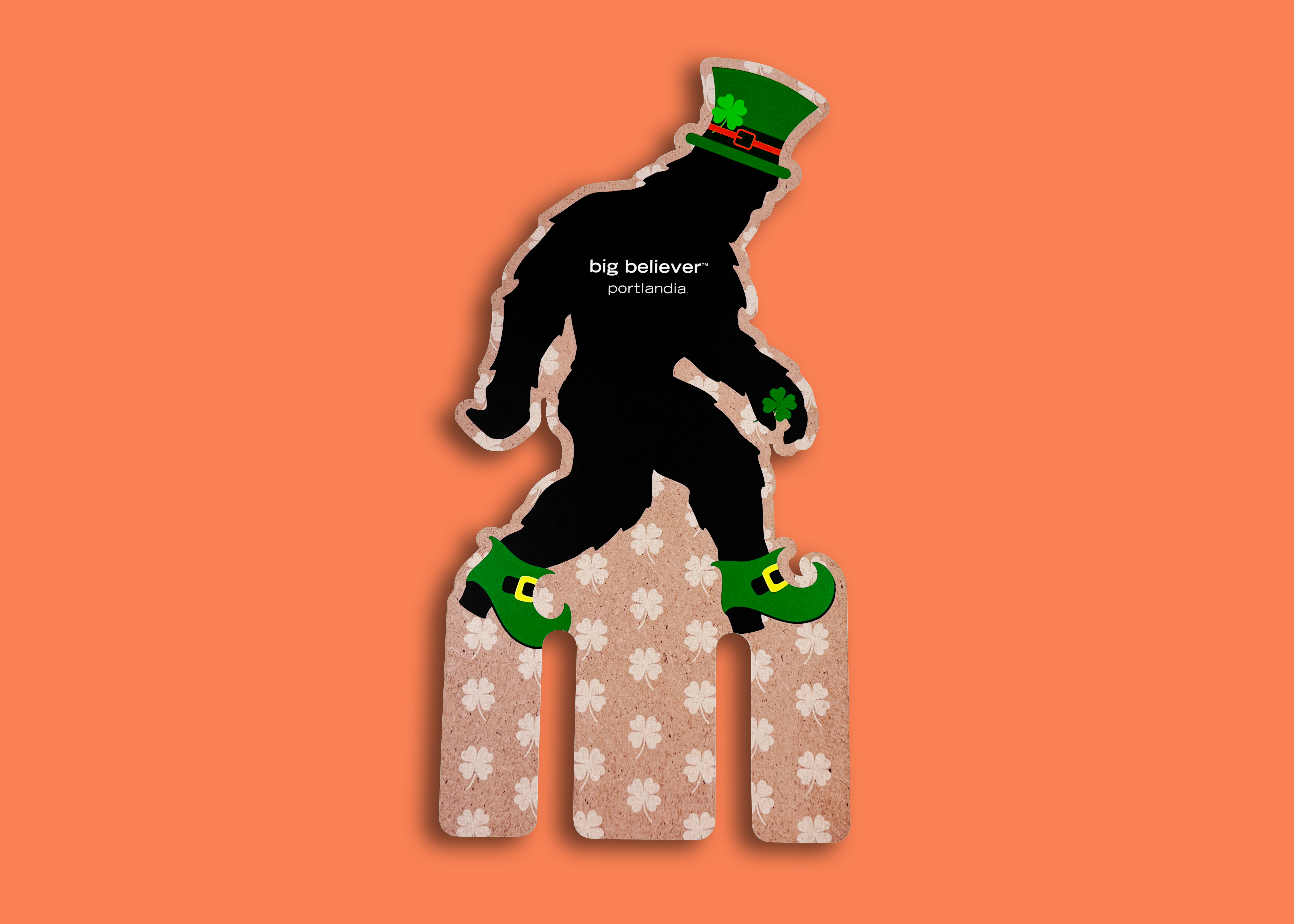Portlandia die-cut case card showing Bigfoot in a leprechaun hat and shamrock-print boots beneath the words big believer